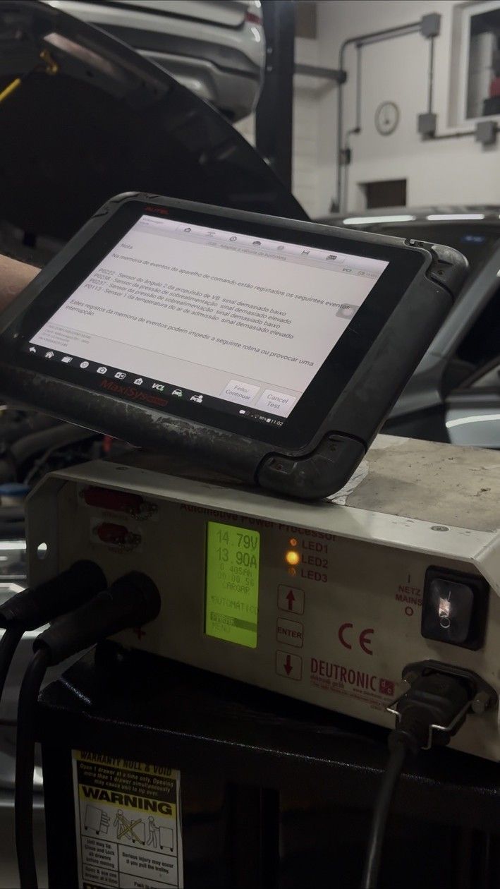 Unidade Deutronic ligada ao veículo na oficina, com um tablet de diagnóstico apoiado sobre ela.