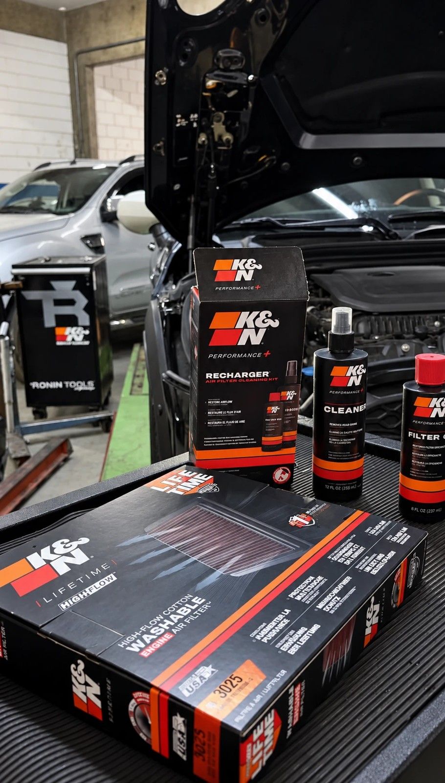 Produtos K&N sobre a bancada da oficina: filtro de ar lavável, kit de recarga e limpador.